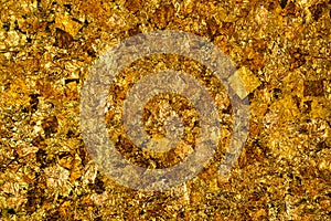 Shiny yellow gold leaf or scraps of gold foil background texture