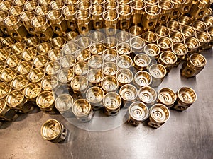 Shiny yellow metal parts background. Shiny brass metal threaded hexagonal parts after turning and machining.