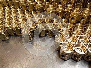 Shiny yellow metal parts background. Shiny brass metal threaded hexagonal parts after turning and machining.