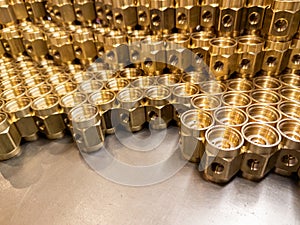 Shiny yellow metal parts background. Shiny brass metal threaded hexagonal parts after turning and machining.