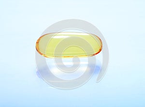 Shiny yellow vitamin omega3 fish oil capsule background.
