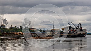 Ship alongside pulp and paper mill on Vancouver Island in Crofton, British Columbia, Canada