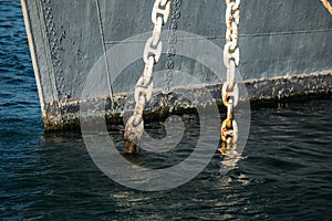 Ship anchor chain in water at harbour pier