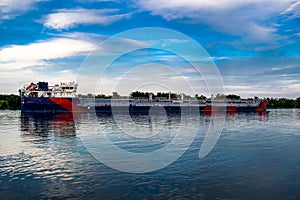 A ship, a barge, a yacht, a boat on the river in the Rostov region. Water transport against the background of a green leafy landsc