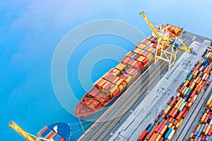 Ship with cargo containers at the marina of an industrial port, aerial view