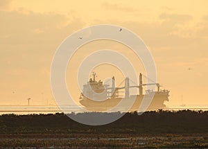 Ship Carrying Windmill Blades in the Shipping Channel at Sunrise