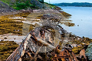 Ship cemetery in Teriberka on the coast of the Barents Sea. Old broken fishing boats in the water on the shore.