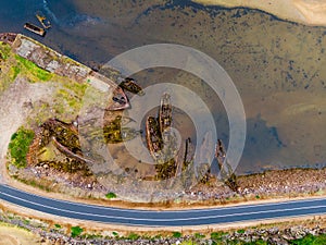 Ship cemetery in Teriberka on the coast of the Barents Sea. Old broken fishing boats in the water on the shore. Kola Peninsula,