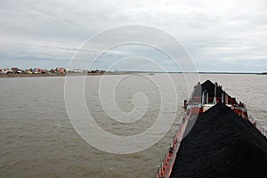 Ship with coal at Kolyma river near village