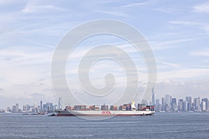 Ship with colorful containers in harbor near new york with blue