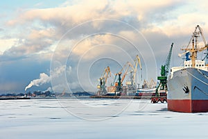 Ship and cranes in the port of winter