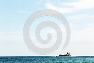 Ship on the crisp blue water with lots of sky and room for text