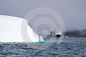 Ship cruises among icebergs on foggy morning