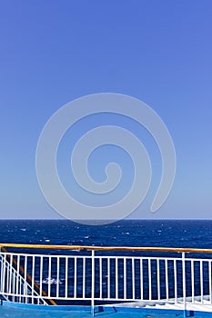 Ship deck railing  while sailing on open sea. Vivid blue color with copy space