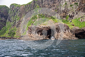 Ship drives into rock formations with gates on Oki Islands, Shimane, Japan, Unesco Global Geopark, Sea of Japan