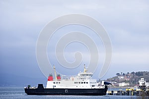 Ship ferry at sea under dark blue storm sky in bad weather photo