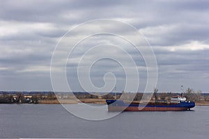 Ship on the IJssel river near Wilsum during a early sunny and misty morning.