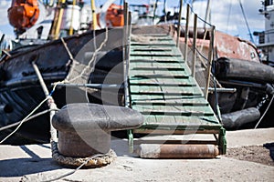 The ship is moored to a dock ladder rope chain