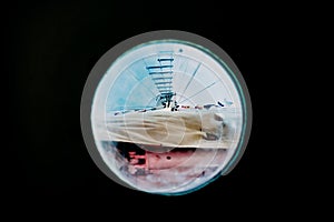 Ship moored to port seen through from inside the porthole of a ship