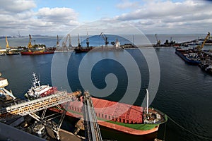 Ship mooring. Big grain terminal at seaport. Preparation of cereals bulk transshipment to vessel. Loading grain crops on photo