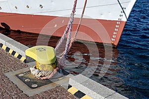 Ship mooring rope moored on the bollard. Moored boat in the port