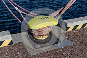 Ship mooring rope moored on the bollard. Moored boat in the port
