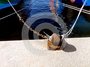 Ship mooring ropes secured around a port bollard