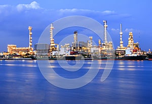 Ship port and oil refinery plant with blue river on twilight tim