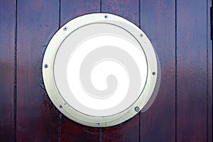 Ship porthole on brown wooden wall background, copy space