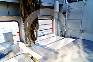 Ship railing on sunny deck with ropes