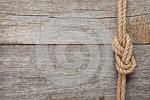 Ship rope knot on wooden texture background