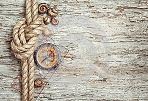 Ship rope, shells, compass and wood background