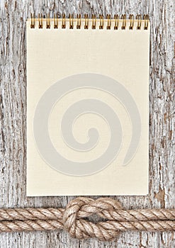 Ship rope, spiral notebook and wood background