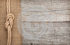 Ship rope on wood and burlap texture background