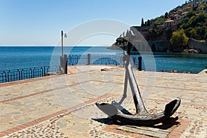 The ship`s anchor is set on the shore near an ancient fortress.