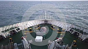 Ship`s bow with all the winches, ropes and anchor moving through the waves