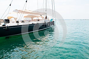 Ship`s bow and aquamarine water in the port of Syracuse, Sicily. Boat and sea, detail. Sailing vessel drops anchor