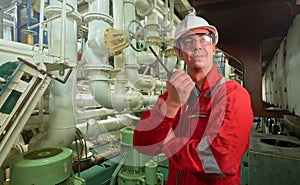 Ship`s mechanic near marine diesel generators on a merchant ship in the engine room