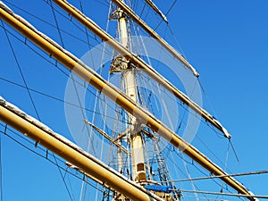 The ship`s rope hangs on the mast of a sailing ship.  A Bay of nylon rope on the deck of a sailboat.