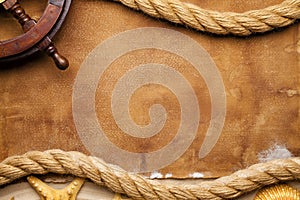Ship`s steering wheel, hawser and seashell on paper and sand photo