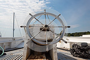 Ship`s wheel helm of an old sailing vessel, boat deck with rope rigging