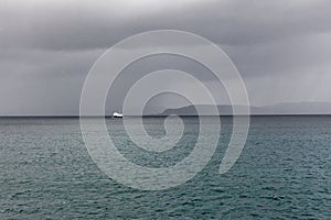 Ship sailing on the blue water of the norwegian fjords in polar day, midnight sun