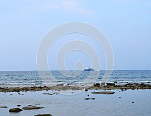 A Ship Sailing at Distance over Sea - Rocky Beach and Clear Sky - Natural Background - Laxmanpur, Neil Island, Andaman, India