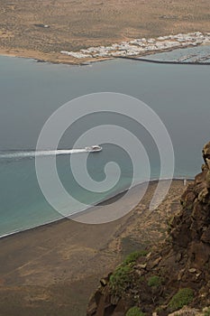 Ship sailing between El Risco beach and Caleta de Sebo.