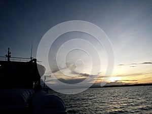 A ship sailing on the ocean at sunrise time