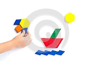The ship sails on the sea waves, the sun shines brightly. Summer happy atmosphere. A child plays with colored blocks