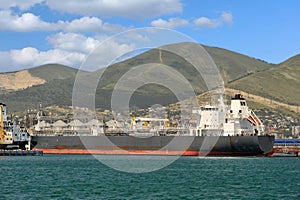 Ship in the seaport against the hills photo