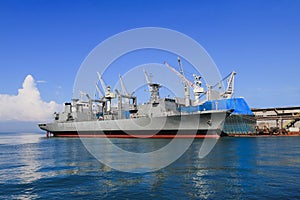 The ship in shipyard during maintenance, alongside near floating dock yard