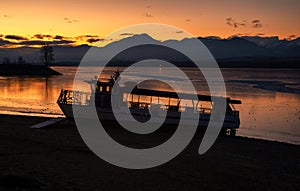 Ship on the shore of lake and beautiful colorful sky in the cold morning. Sunrise in bright colors on Dam Liptovska Mara, Slovakia