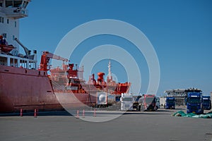 The ship-tanker with oil is unloaded in the fuel trucks in port.